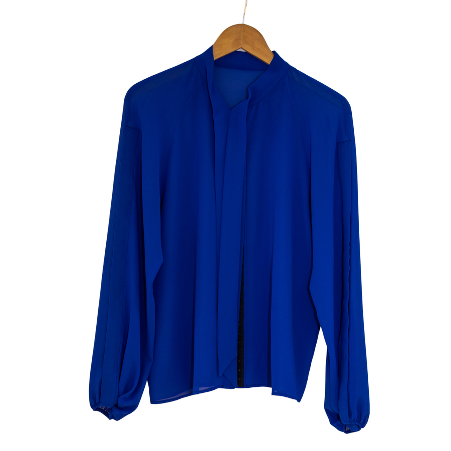 Flat lay of a royal blue chiffon pussy bow tie shirt on a hanger with the tie undone.