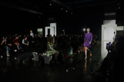a woman walking on a runway in front of a crowd of people