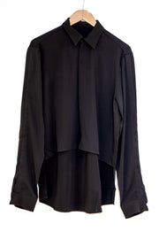 Black lyocell shirt on a wooden hanger against white background. Concealed front fastening and sleeve opening.